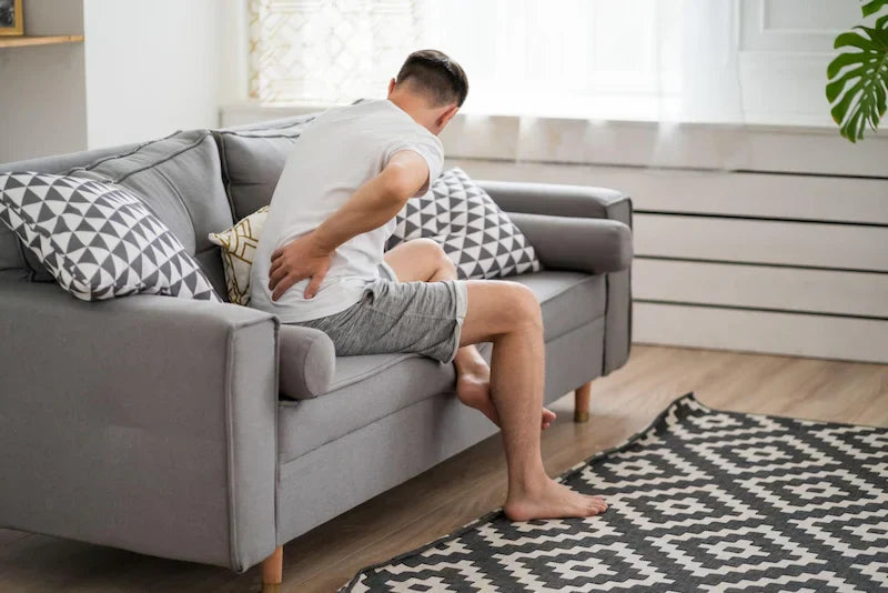 Person supporting kidney area with hydration routine including warm water and shilajit resin