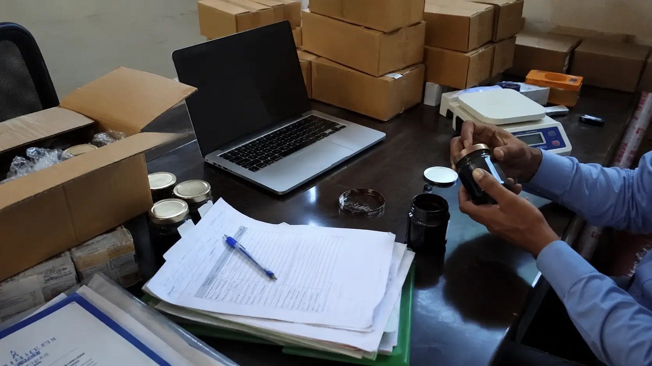 Wholesale shilajit sourcing setup with cartons, samples, invoice papers, and resin.